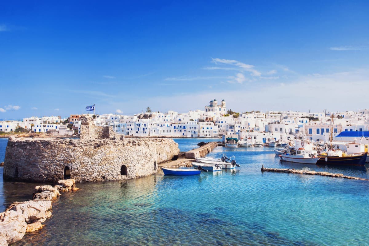 Traditional fishing boats in Naoussa harbor with waterfront restaurants
