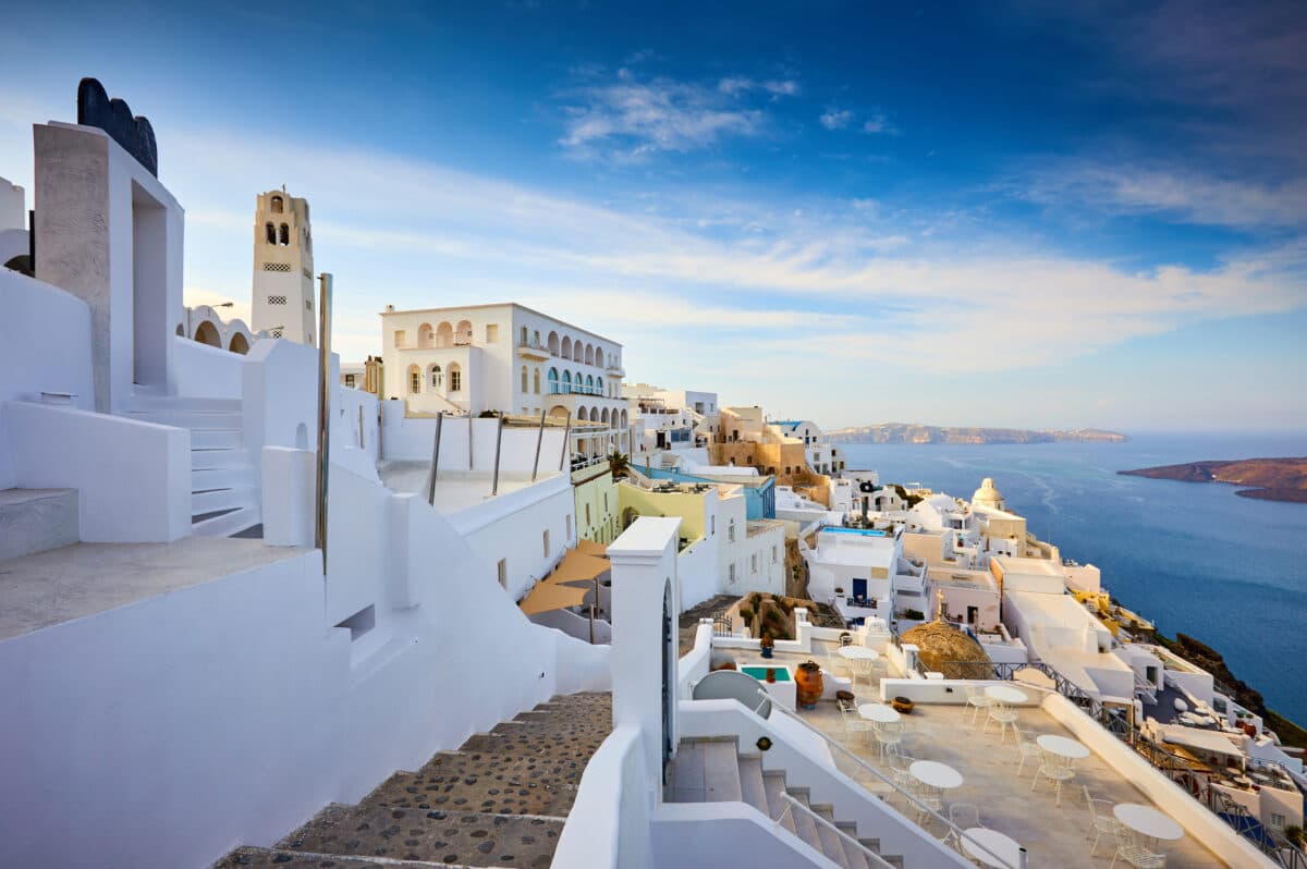Beautiful Fira town on Santorini with blue-domed churches and cliffside terraces overlooking the Aegean Sea.