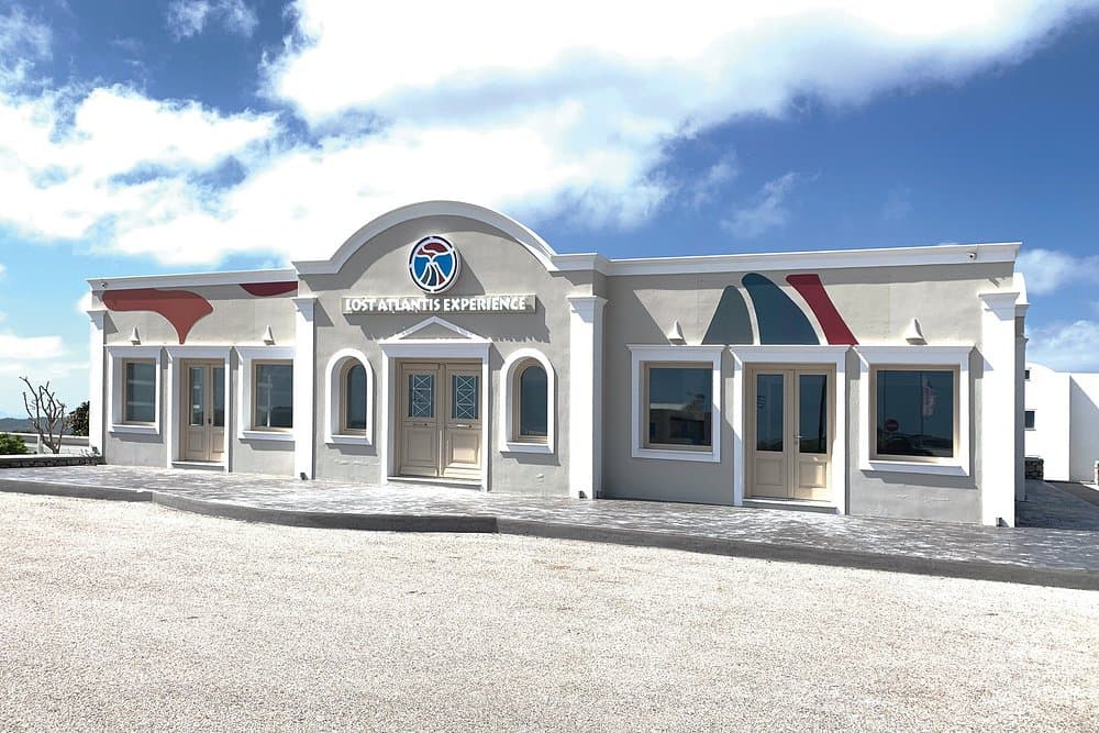 Modern Lost Atlantis Experience Center with minimalist design, logo, and scenic coastal surroundings.