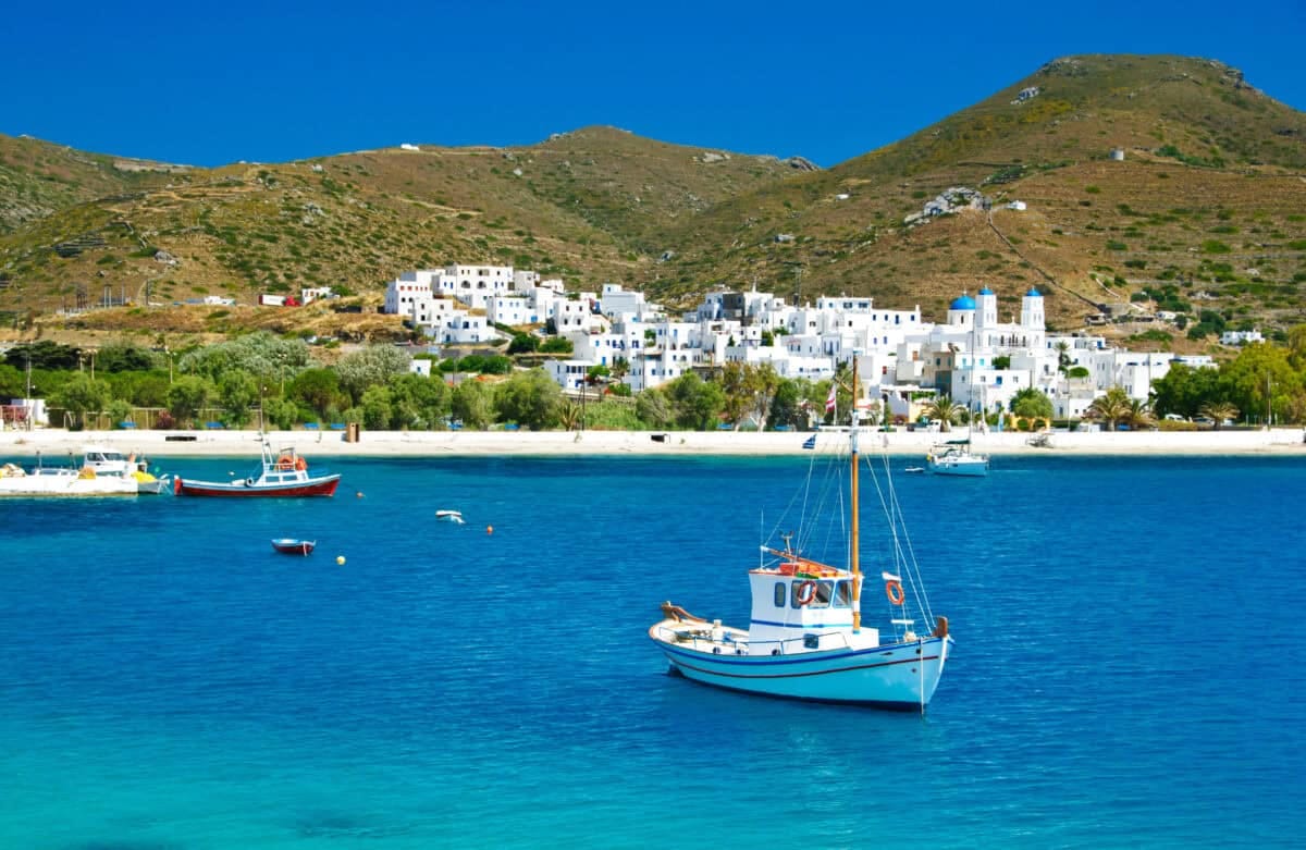 Beautiful Greek island of Katapola Bay on Amorgos with white houses, blue-domed church, and boats.