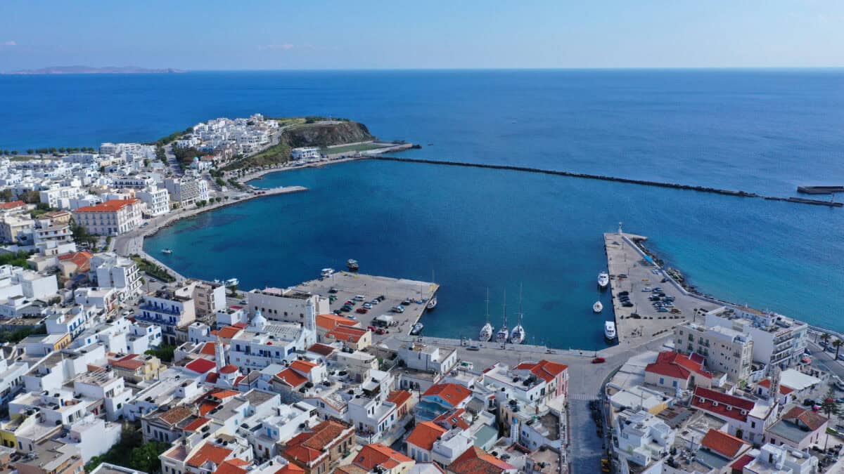 Aerial view of Tinos Island port, Cyclades, Greece, with Panagia Megalochari Monastery and whitewashed town.