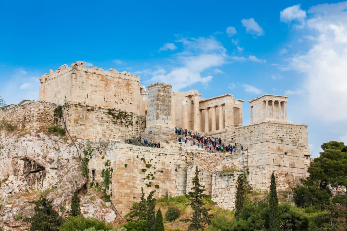 Tourists enjoy the iconic Acropolis of Athens from Areopagus Hill on a sunny spring day.
