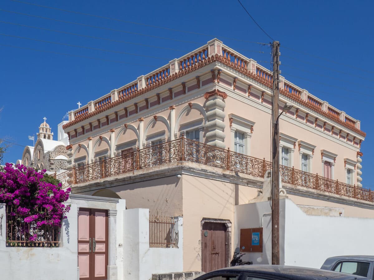 Argyros Mansion Mediterranean architecture with pastel building, ornate details, vibrant flowers, and historic surroundings.