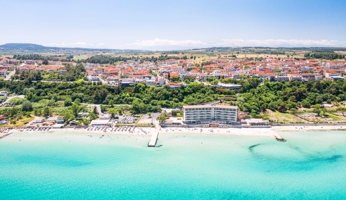 Beautiful waterfront view of Kallithea, Halkidiki, Greece with beaches, white buildings, and lush greenery.