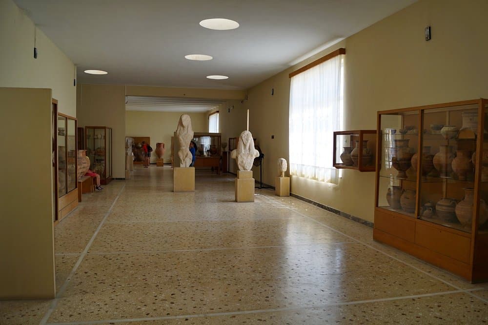 Archaeological Museum of Thera interior showcasing ancient pottery and stone sculptures in a well-lit, organized gallery space.