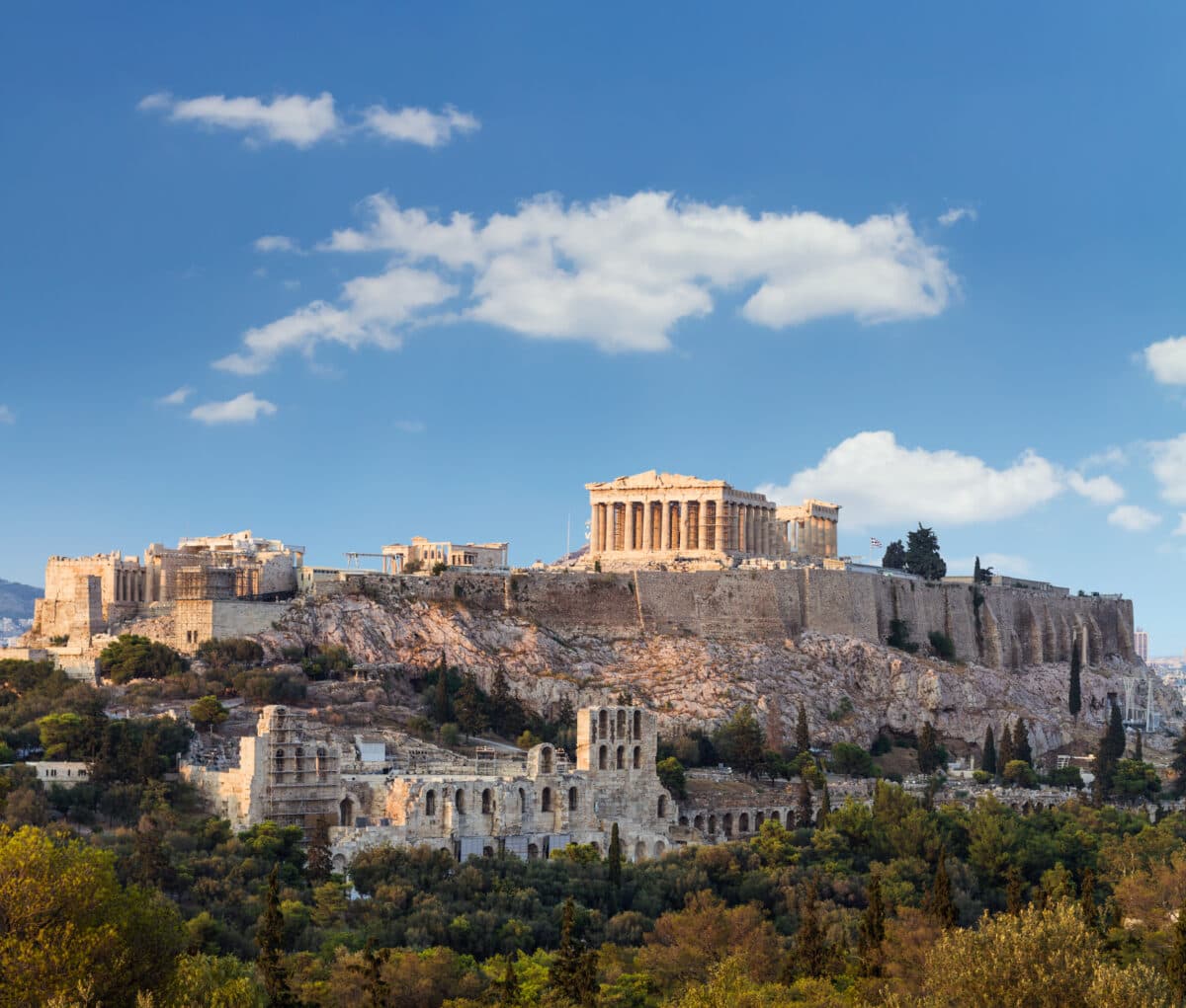 Ancient Parthenon temple atop Athens Acropolis with marble columns, historical ruins, and scenic Greek landscape.