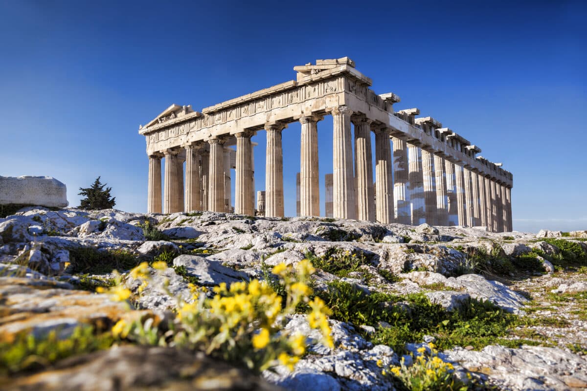 Parthenon on Athens Acropolis with spring flowers and clear blue Mediterranean sky.