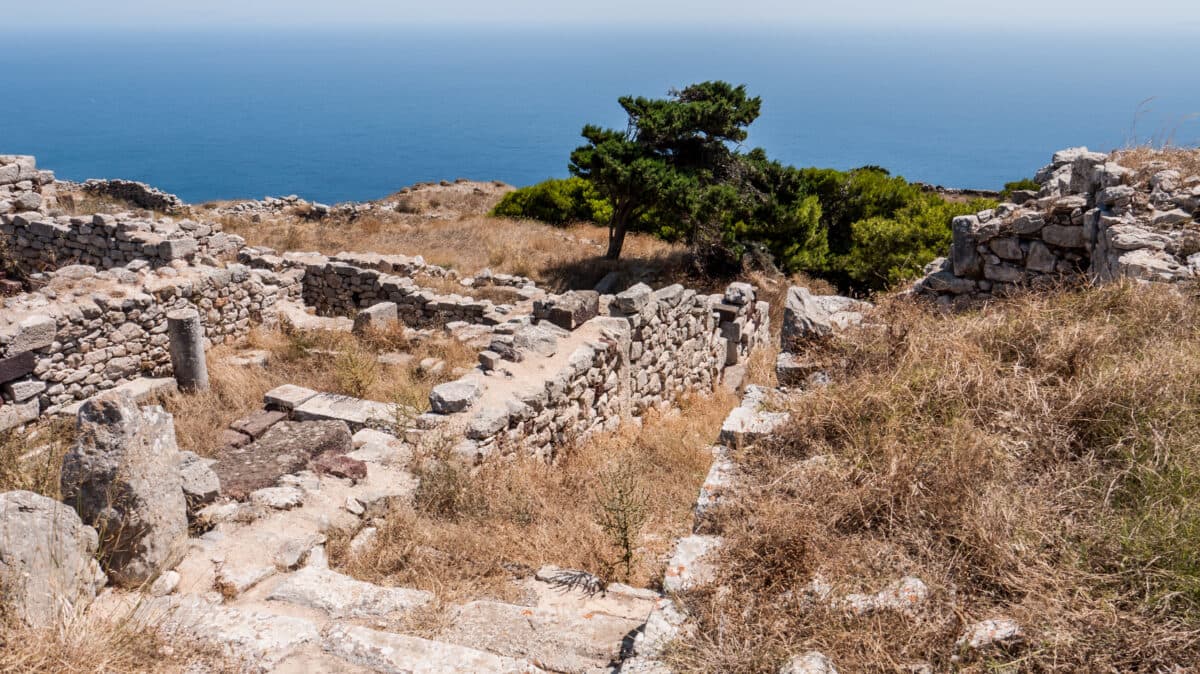 Ancient Thera ruins on Santorini, Greece, with stone walls, Aegean Sea views, and Mediterranean landscape.