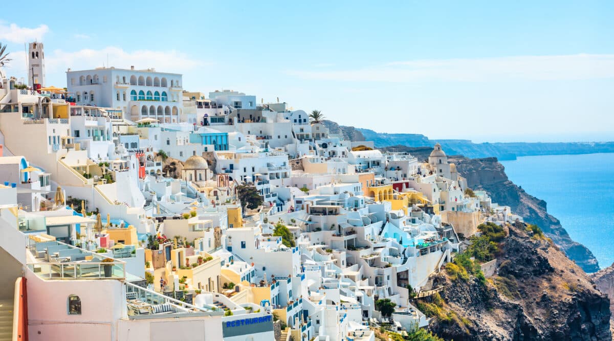 Panoramic view of Fira, Santorini with whitewashed Cycladic architecture and stunning Mediterranean coastline.