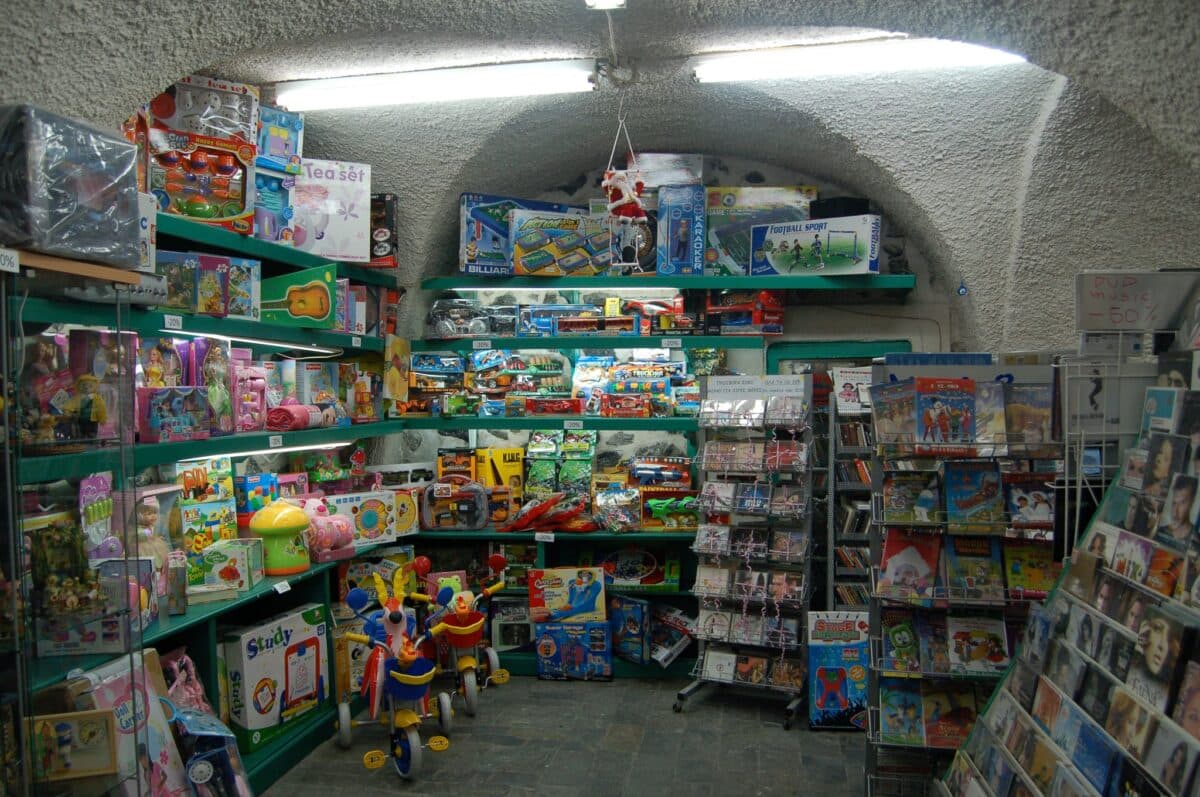 Close-up of a toy store interior with dolls, games, DVDs, and media discounts in Xani Santorini